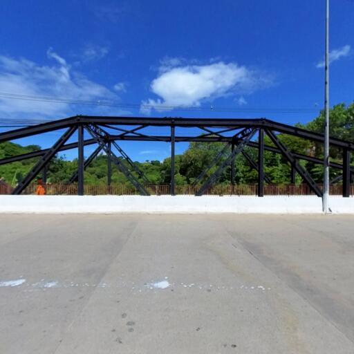 Estrutura preta da Ponte Metálica sob céu azul